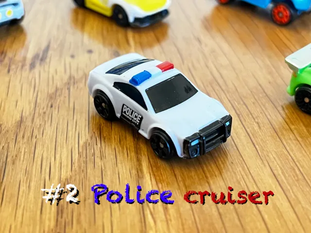 A carousel photo displaying the second vehicle named 'Police cruiser' out of an array of 'Standard cars', at full size. The car is painted white with a 'Police Micro City' text printed on the right door.