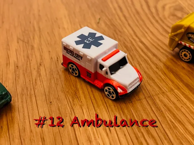 A carousel photo displaying the twelfth vehicle named 'Ambulance' out of an array of 'Large Vehicles', at full size. The truck is painted white with the following title 'Micro City Fire and Rescue' printed on the right side base cover.