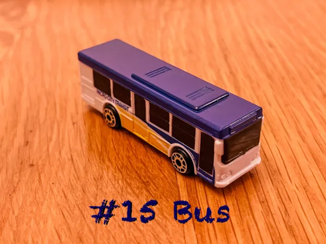 A carousel photo displaying the fifteenth vehicle named 'Bus' out of an array of 'Large Vehicles', at full size. The bus is painted blue with an white undercoat, with the company title 'Micro City Transit' printed on the right side base cover.