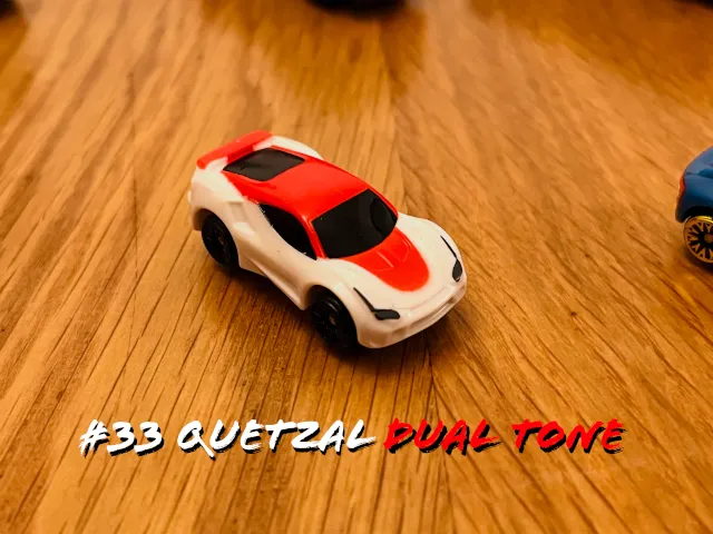 A carousel photo displaying the thirty-third vehicle named 'Quetzal Dual Tone' out of an array of 'Deluxe Cars', at full size. The car is mostly painted white, with the middle covered with red.