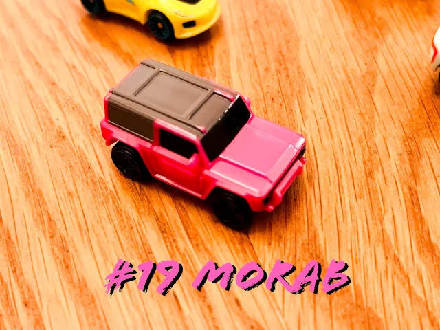A carousel photo displaying the nineteenth vehicle named 'Morab' out of an array of 'Deluxe Cars', at full size. The car is painted pink with it's top painted brown.