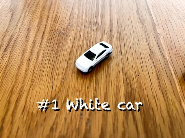 A carousel photo displaying the first car named 'White car' out of an array of V.I.A. 'mini Standard cars', at mini size. The car is painted white with a standard SUV design.