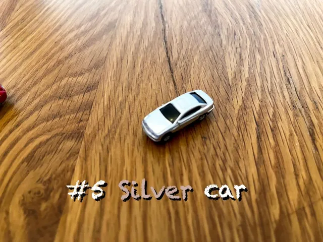 A carousel photo displaying the fifth car named 'Silver car' out of an array of V.I.A. 'mini Standard cars', at mini size. The car is painted whitish-silver with a standard SUV design.