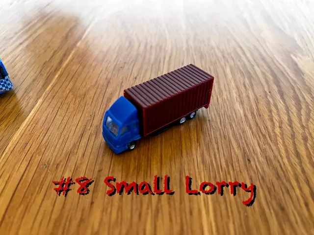 A carousel photo displaying the eighth vehicle named 'Small Lorry' out of an array of V.I.A. 'mini Large Vehicles', at mini size. The vehicle is painted Dimgray, blue front with an overall standard lorry design.
