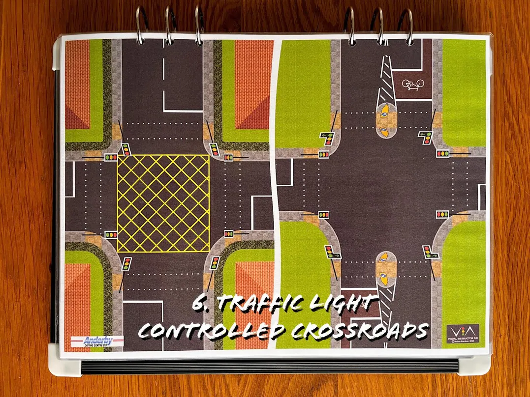 A carousel photo displaying the sixth plan named 'traffic light controlled crossroads' out of an array of roads layouts, at full size. Consisting of two designs of traffic light controlled crossroads with a difference. One with a box junction and one without.