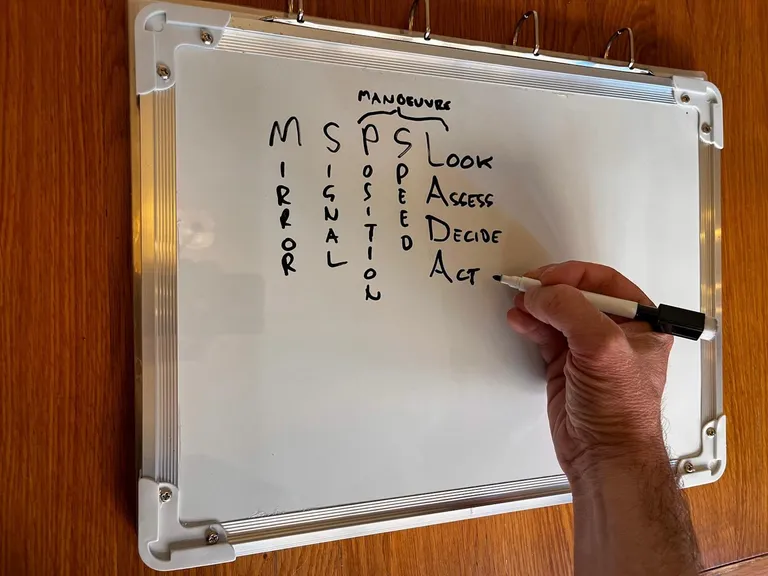Julian writing the MSM(PSL), LADA and P.O.M using the V.I.A. whiteboard and black marker pen.