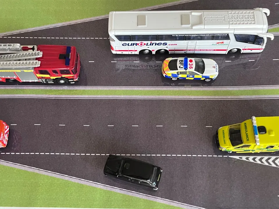 Demonstrating a black magnetic miniature car exiting out of a slip road joining a dual carriageway.