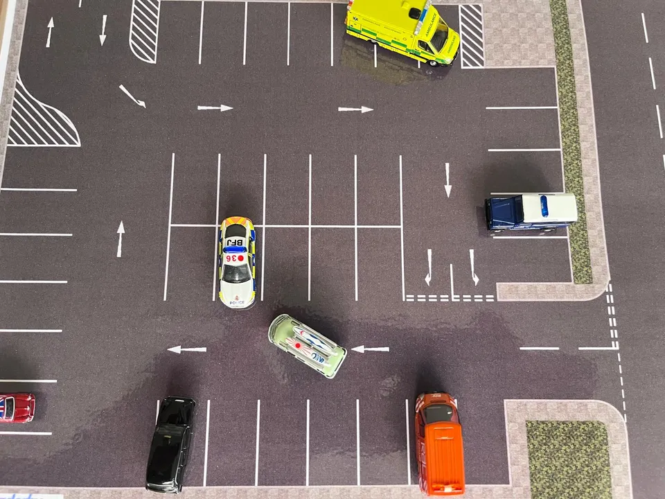 A green magnetic vehicle demonstrating a forward bay park on the car park road layout.